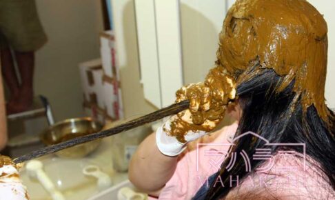 ロングヘアーの女性がヘナする様子